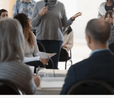 Une femme qui parle face à une assemblée