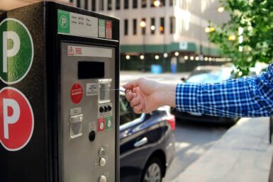 Un homme paie pour son stationnement à une borne automatique