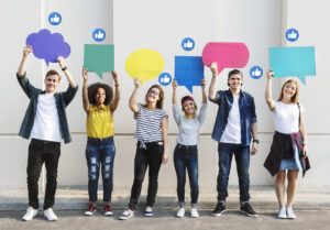 Un groupe de jeunes tient à bout de bras des bulles de dialogue colorées, et des "like" flottent au-dessus de leurs têtes