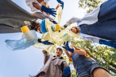 Des jeunes armés de gants ramassent des déchets ; vue en contre-plongée