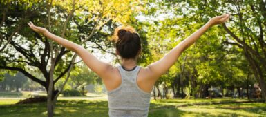 Une sportive vue de dos dans un parc arboré