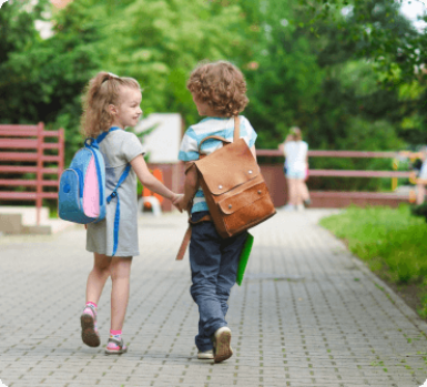 deux jeunes enfants portant des cartables et se tenant la main