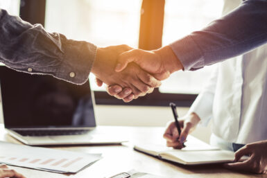 hommes qui ce serres la main au dessus de papier de contrat