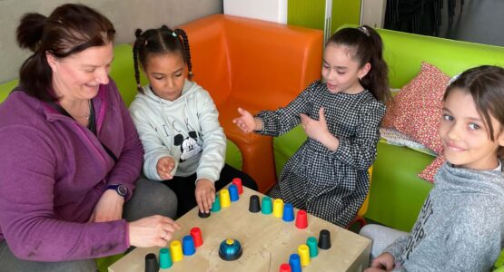 jeu autour d'une table avec enfants et adulte au centre social la mosaïque